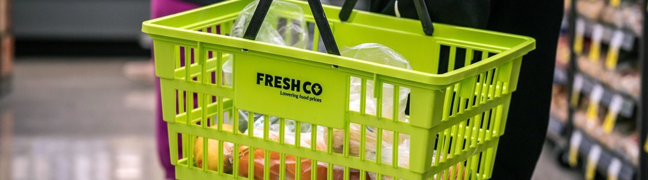 Customer holding full Freshco basket in-store